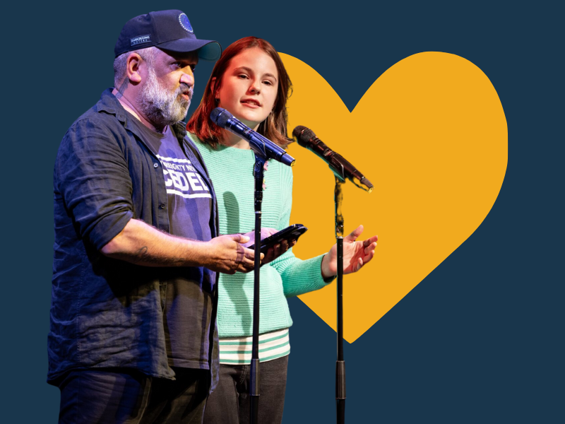 Image of Rob Waters and KJ Hayward both standing behind microphones. The image has a blue background with a yellow heart.