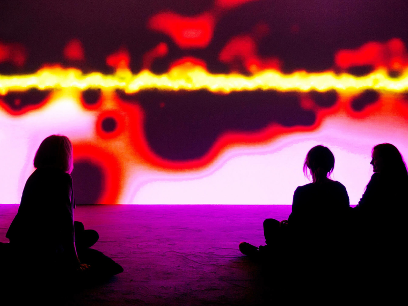 image of young people sitting in front of Susan Hiller video work, Resounding (infra-red)